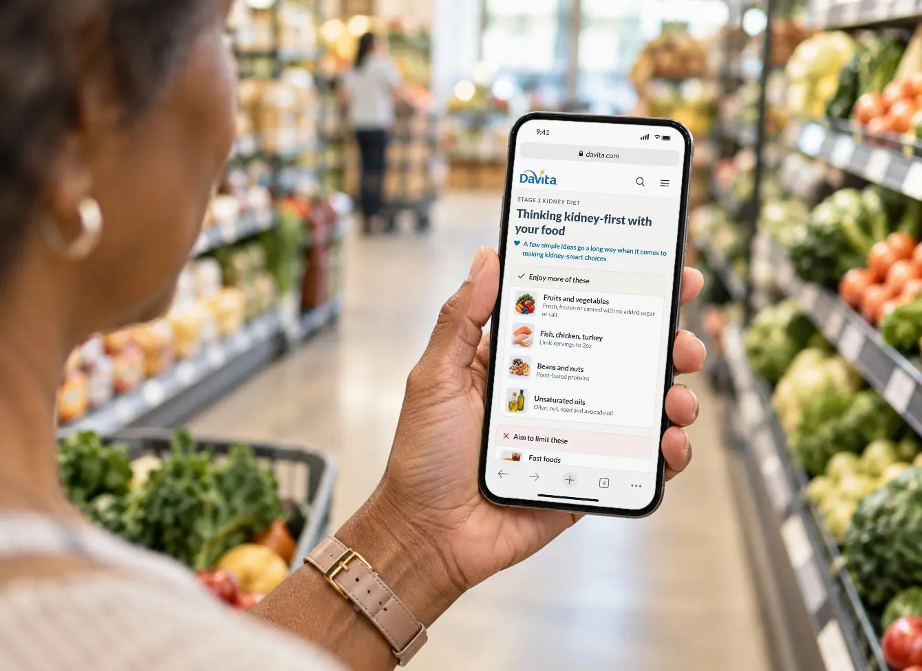 A shopper in a grocery aisle checks DaVita's kidney-friendly food guide on her phone